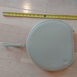 Vintage taupe round case with wrist strap.